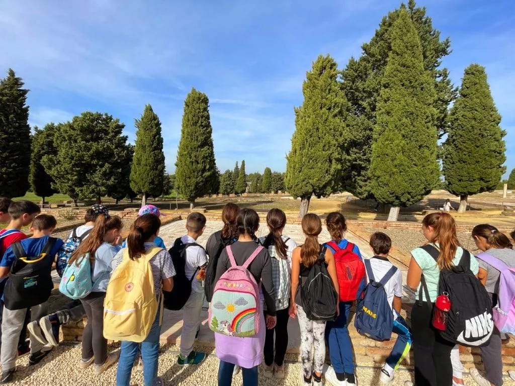 Grupo disfrutando de una visita guiada en Itálica